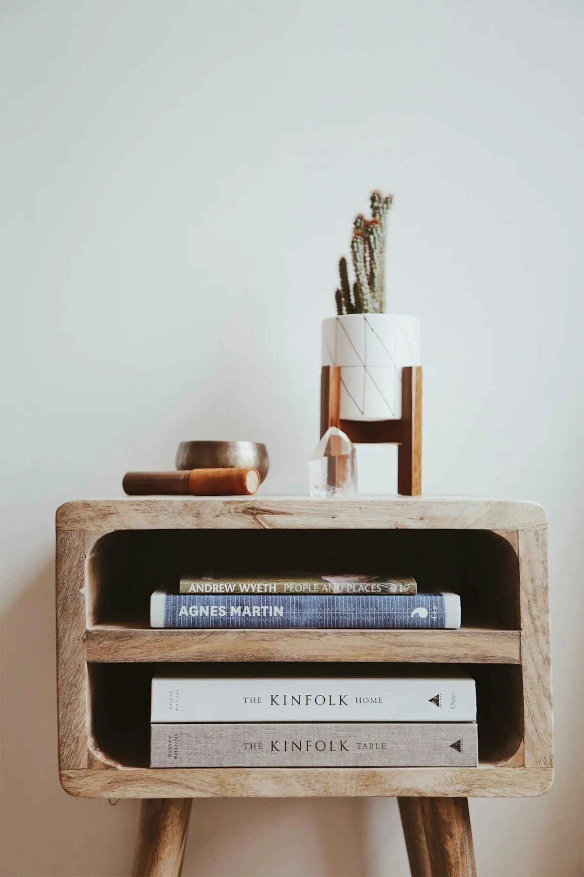 Mesita moderna de madera clara con libros y objetos decorativos